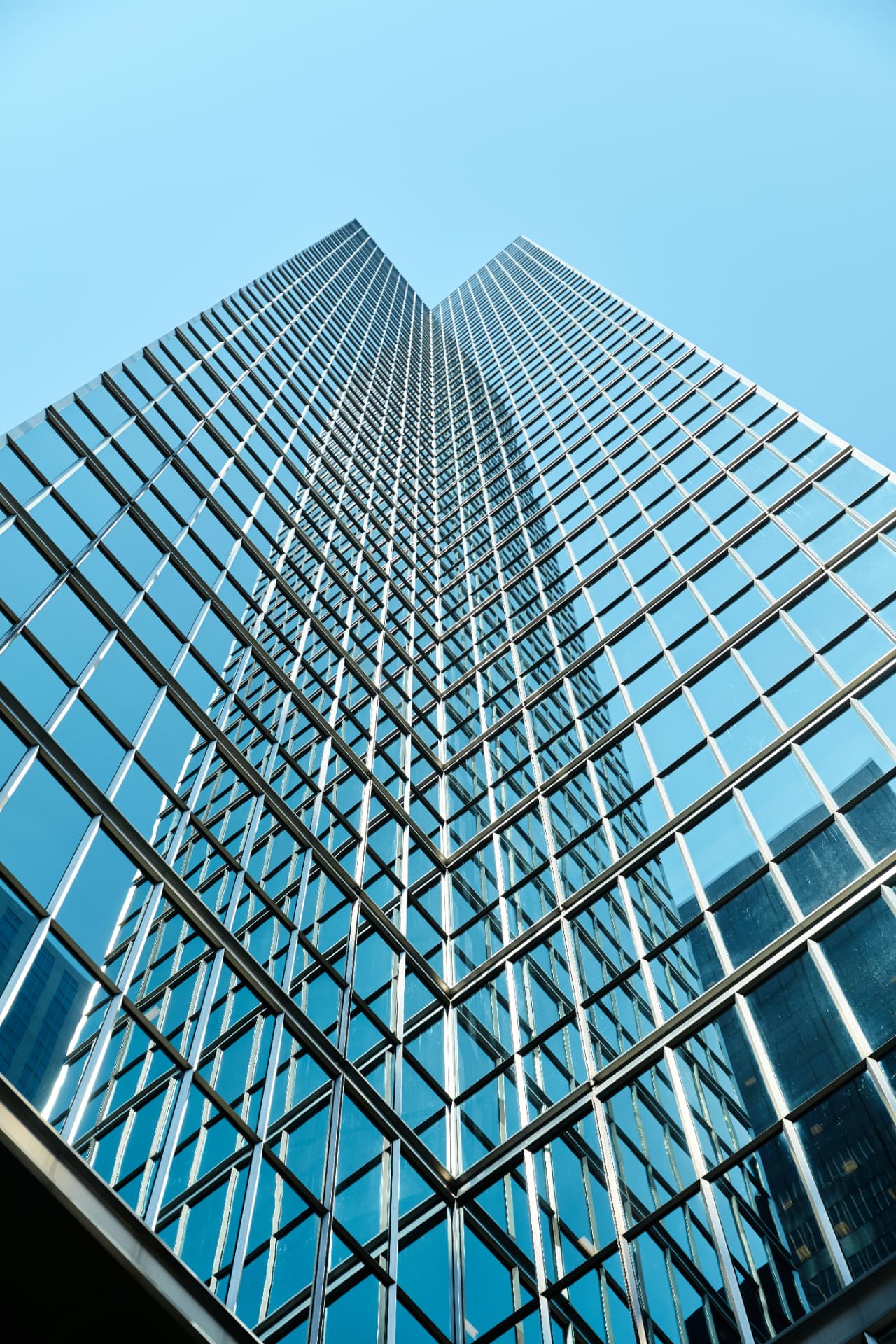 Upward view of a modern glass and steel corporate tower